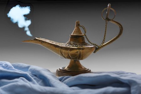 Photo for Blue smoke coming out a genie lamp and beautiful colored cloth - Royalty Free Image