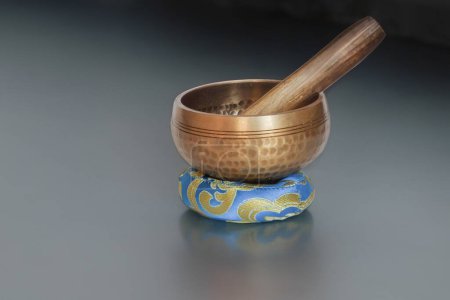 Photo for Brass hand hammered brass bowl on a grey surface used for spiritual practices and meditation - Royalty Free Image
