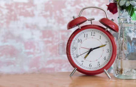 Photo for Vintage retro old fashioned red alarm clock with the time set for waking up - Royalty Free Image