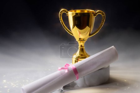 Photo for Gold trophy with certificate of achievement on a silver coated stage - Royalty Free Image