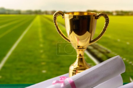 Téléchargez les photos : Trophée d'or avec certificat de réussite avec piste d'athlétisme - en image libre de droit