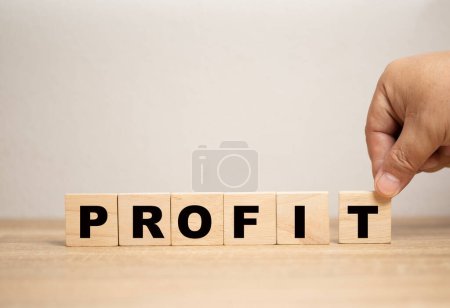 business profit concept. Businessman placing wooden block letter T per word to complete word profit. Planning and strategy for future profitability and growth of corporate company.