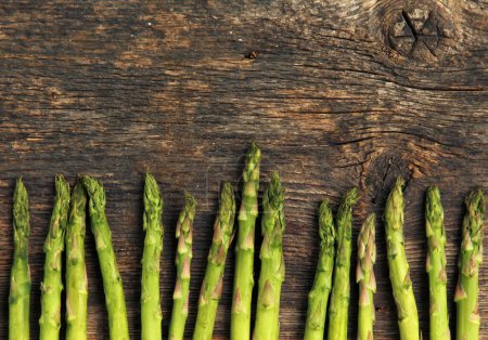 Row of asparagus on a rustic wooden background