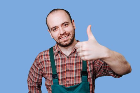 Photo for Delivery concept, portrait of A joyous, laughing young happy delivery man standing and showing thumbs up for successful parcel delivery, copy space. Banner. profession, construction and building - Royalty Free Image