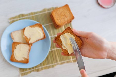 A product shot of butter being spread on a piece of bread, emphasizing the importance of healthy eating habits.