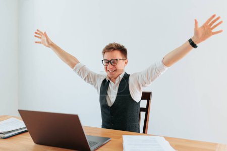 Ein Büroangestellter, während er eine herausfordernde Aufgabe auf seinem Computer erledigt. Das Gefühl der Erfüllung und Zufriedenheit ist in seinem Ausdruck sichtbar, was zeigt, wie sehr ihm seine Arbeit Spaß macht..