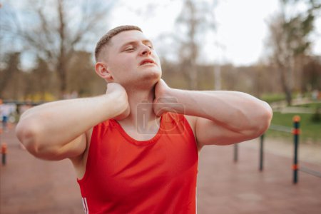 Photo for Painful Training A Cautionary Tale of Outdoor Workouts. A caucasian guy with a strained neck looks up at the sky, seeking relief from his neck pain after an intense sporting event. - Royalty Free Image