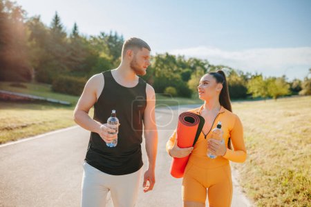 Photo for Active Lifestyle Back View of Two Young Athletes in Sportswear Chatting Outdoors After Workout, Athletic Togetherness Back View of Two Young Adults in Sportswear Chatting Outdoors After Workout - Royalty Free Image