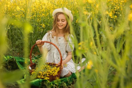 artistic portrait of a lovely glad little child girl in the dress, on a natural yellow background with flowering rapeseed. rustic, fine art