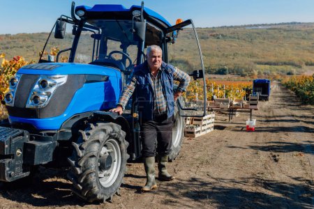 senior farmer takes center stage as he poses beside his tractor, a testament to his unwavering commitment to agriculture and the timeless traditions of farming.