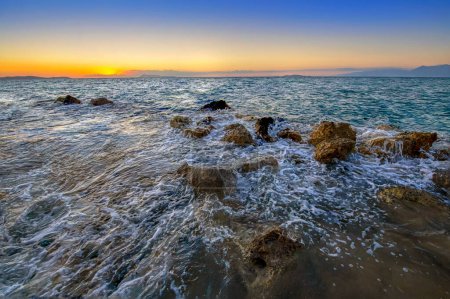 Foto de Hermosa puesta de sol en la playa de Logas en el pueblo de Peroulades de la isla de Corfú, Grecia. Fondo natural colorido perfecto para un texto - Imagen libre de derechos