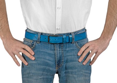 Téléchargez les photos : Gros plan d'un bel homme portant une chemise blanche et un pantalon en jean avec ceinture en cuir bleu, isolé sur fond blanc avec un chemin de coupe - en image libre de droit