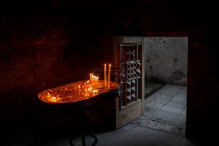 Téléchargez les photos : Bougies dans le monastère de Haghartsin (XIIIe siècle) à Dilijan, Arménie et une porte d'entrée ouverte en bois sculpté - en image libre de droit