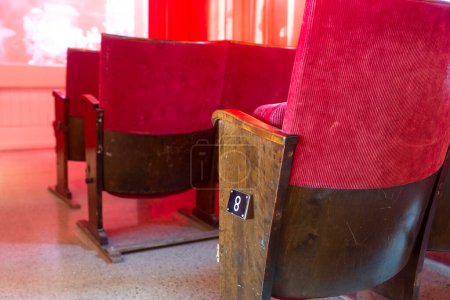 Photo for Close up of empty vintage numbered red cinema seats in movie theater - Royalty Free Image