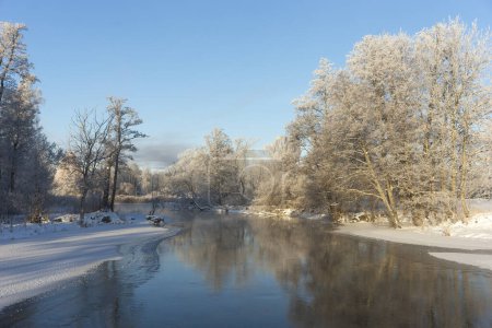 Photo for River on cold winter day, with trees covered in snow or frost, reflected in the water - Royalty Free Image