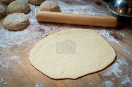 Téléchargez les photos : Gros plan du déploiement de la pâte à pizza sur la table de cuisson - en image libre de droit