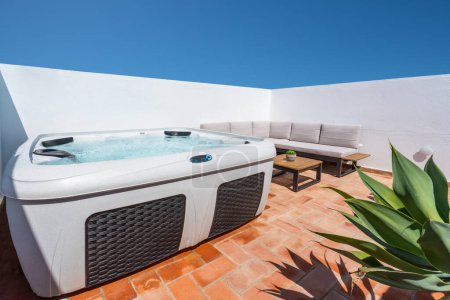 Foto de En la terraza de la casa hay una moderna bañera de hidromasaje al aire libre para que los turistas se relajen. Foto de alta calidad - Imagen libre de derechos