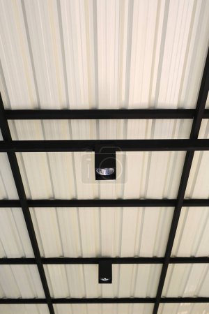 Téléchargez les photos : Ampoule suspendue au toit de la structure en tôle. - en image libre de droit