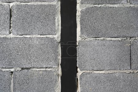 Téléchargez les photos : Nouveau bloc de brique de béton texture de fond de mur avec du métal noir au centre. - en image libre de droit