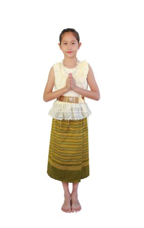 Téléchargez les photos : Belle fille asiatique enfant en robe traditionnelle thaïlandaise sarong avec respect Pay, symbole Sawasdee, geste de bienvenue isolé sur fond blanc. Image pleine longueur avec chemin de coupe. - en image libre de droit