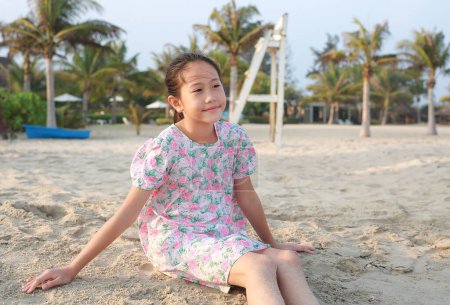 Téléchargez les photos : Portrait de sourire asiatique jeune fille enfant couché sur la plage de sable pendant les vacances d'été. - en image libre de droit