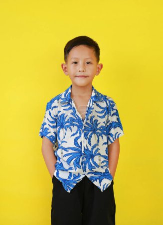 Téléchargez les photos : Portrait de garçon asiatique en costumes d'été selon la culture thaïlandaise pour célébrer le festival Songkran des gens sur le Nouvel An Thaïlande sur fond jaune. - en image libre de droit