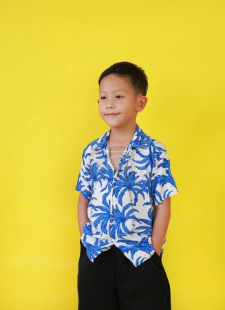 Téléchargez les photos : Portrait de garçon asiatique en costumes d'été selon la culture thaïlandaise pour célébrer le festival Songkran des gens sur le Nouvel An Thaïlande sur fond jaune. - en image libre de droit