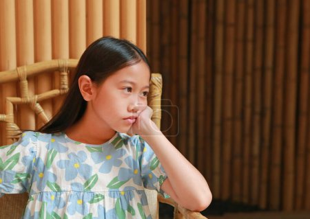 paisible asiatique fille enfant âge environ 9 ans assis sur canapé chaise et couché sur table en marbre avec vue sur.
