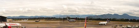 Photo for Bogota, Colombia - September, 2019: Airplane of airline Avianca and other airplanes at Bogota airport. View for the mountains around the El Dorado International Airport. South America, Latin America - Royalty Free Image