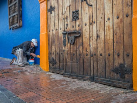 Photo for Bogota, Colombia - September 13, 2013: Colombian man is painting the wall on the street of Bogota - Royalty Free Image