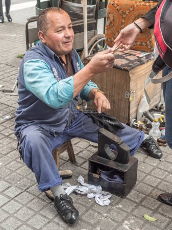 Photo for Bogota, Colombia - September 13, 2013: Shoeblack is cleaning the shoes on the street of Bogota - Royalty Free Image