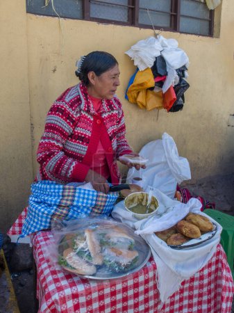 Téléchargez les photos : Urubamba, Pérou - 19 mai 2016 : Femme vend de la nourriture péruvienne dans la rue d'Urubamba. Amérique latine. - en image libre de droit