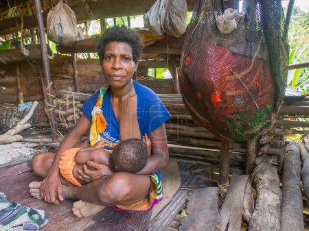 Foto de Papua, Indonesia - 16 de enero de 2015: Residentes de una selva lejana en su entorno natural. Tribu Korowaya. Constructores de casas en los árboles. - Imagen libre de derechos