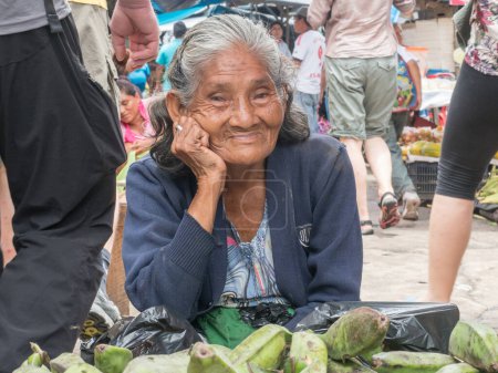 Foto de Iquitos, Perú 27-mar-2018: Retrato de una mujer con una piel roja vendiendo plátanos en el mercado de Belén, selva amazónica. Sudamérica. Amazonia. - Imagen libre de derechos
