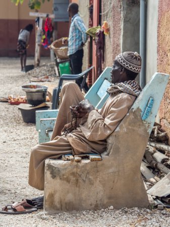 Photo for Joal-Fadiout, Senegal - January, 26, 2019: Black man praying on the Tasbih Muslim rosary. Joal-Fadiouth town and commune in the This Region at the end of the Petite Cte of Senegal. Africa. - Royalty Free Image
