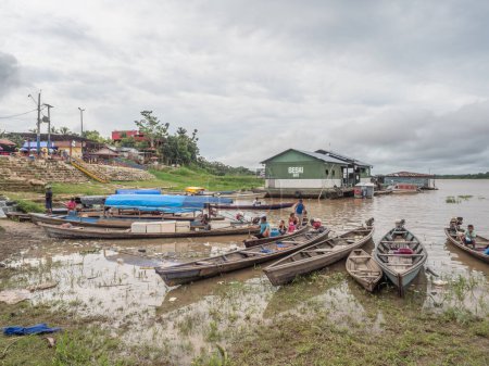Foto de Tabatinga, Brasil - 25 de noviembre de 2018: Personas en el barco de madera en el puerto del río Amazonas. Sudamérica. Río Amazonas. Tres fronteras. Bosque lluvioso de la Amazonía. - Imagen libre de derechos