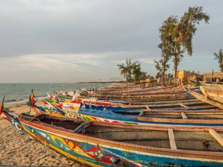 Photo for Nianing, Senegal - January 24, 2019: Colorful wooden fisher boat standing on the sandy beach in Senegal. Africa - Royalty Free Image