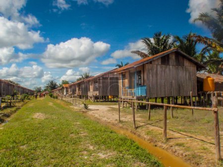 Photo for Mabul, Indonesia - January 19, 2015: Small village Mabul with very simple wooden houses built by the government of Indonesia on the bank of Mabul River for Korowai tribe. West Papua. - Royalty Free Image