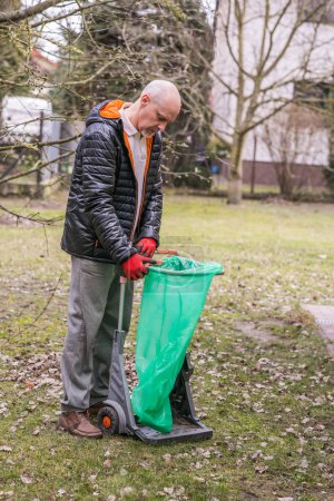 Photo for Mature man with a small beard during spring cleaning in the garden - Royalty Free Image