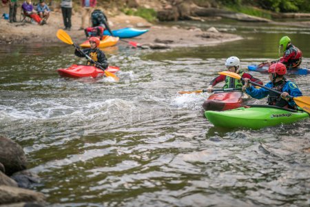 Photo for Jozefow, Poland - May  12: Water canoeing, extreme kayaking. Kayakers  in a small sport kayaks are practicing  an approach to a cascade on the Swider River in Poland - Royalty Free Image