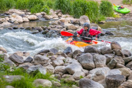 Photo for Jozefow, Poland - May  12: Water canoeing, extreme kayaking. The guy in a small sport kayak practices an approach to a cascade on the Swider River in Poland - Royalty Free Image