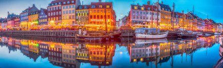 Photo for Nyhavn (New Harbour), Copenhagen, Denmark - 14 JMay 2019: Panoramic view of Nyhavn pier with color buildings, ships, yachts and other boats in the Old Town of Copenhagen, Denmark, Europe. Night time, - Royalty Free Image