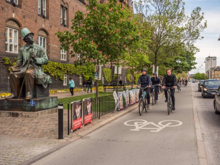 Foto de Copenhague, Dinamarca - 1 de mayo de 2019 - Estatua de bronce de Hans Christian Andersen por el escultor Henry Luckow-Nielsen junto al Ayuntamiento y carril bici en Kopenhagen - Imagen libre de derechos
