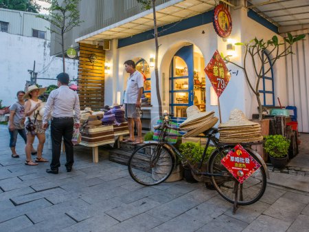 Téléchargez les photos : Tainan, Taïwan - 10 octobre 2016 : Bazar typique à Taïwan avec beaucoup de produits locaux et des chapeaux de paille sur le vélo - en image libre de droit