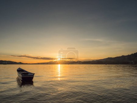 Foto de Slhouette of boat at the tropical sunset, view from beach on Ambon Island. Indonesia, Maluku, Maluki, - Imagen libre de derechos
