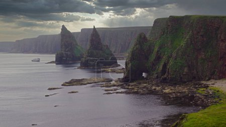 Photo for View of the stacks in the fog. Duncansby Head is the northeastern tip of Scotland, close to the village of John o Groats.  Duncansby Head is particularly spectacular because of the rock needles, the so called Duncansby Stacks. - Royalty Free Image