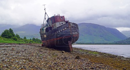 Photo for An old fishing trawler lies on the beach at Corpach, Fort William in the Highlands of Scotland - Royalty Free Image