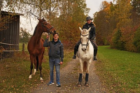 Photo for Shooting with brown Rhineland gelding, white mare, her rider and friend - Royalty Free Image