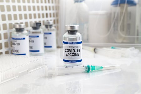 Foto de COVID-19 Vacuna Vial para dosis de refuerzo inyectado contra variantes omicrónicas vacunación. Frasco de jeringa y vacuna contra el Coronavirus con el nombre de la vacuna covid-19 en la etiqueta - Imagen libre de derechos