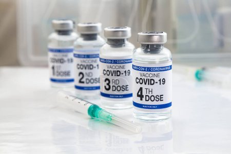 Foto de Vacuna contra el Coronavirus etiquetada como primera, segunda, tercera y cuarta dosis de vacuna en la etiqueta. COVID-19 viales de vacuna para la vacunación etiquetados como 1ª, 2ª, 3ª y 4ª dosis para la inyección de refuerzo para la variante omicrónica - Imagen libre de derechos